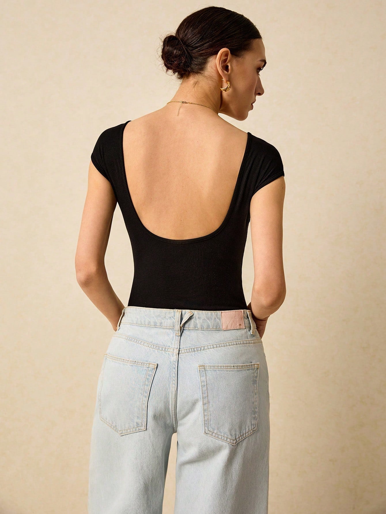 Plain Ribbed Knit Bodysuit Is A Form-Fitting Bodysuit Made Of Ribbed Elastic Material With A Backless Design